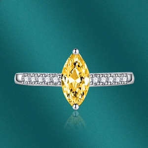 Macro detail of marquise-cut yellow gemstone ring with pavé side stones on silver band