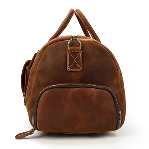 Detail of vintage brown leather travel bag featuring reinforced stitching and D-ring buckle
