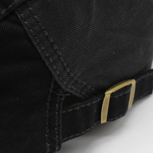 Detail view of cotton beret featuring a golden metal buckle and adjustable strap