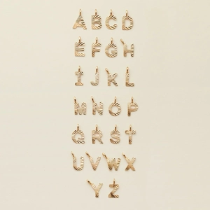 Detailed view of the full A-Z set of gold sunburst textured initial letter pendants