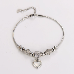 Detailed macro view of snake chain bracelet with heart charm and steel engravings