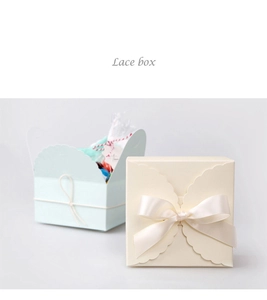Detailed macro view of square paper gift boxes with lace edges and ribbon bows