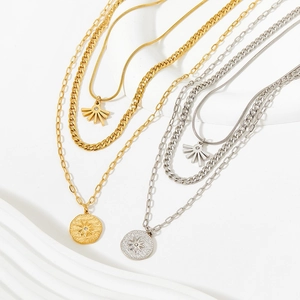 Three-layer stainless steel necklace set with sunburst pendant and geometric coin charms
