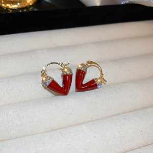 Detail of V-shaped red enamel earrings with gold trim and sparkling rhinestones
