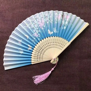 Detail of silk folding fan with blue gradient cherry blossoms and pink tassel