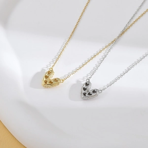 Detalle de collares de corazón en oro y plata con micro-incrustaciones sobre cerámica