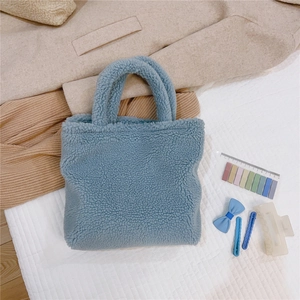 Dettaglio della borsa tote in peluche celeste con morbida pelliccia sintetica e manici