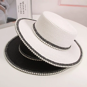 Close-up of elegant wide-brim straw hats with pearl trim and mixed woven bands
