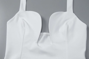 Close-up of the white deep U-neckline with smooth fabric on a sleeveless fitted top