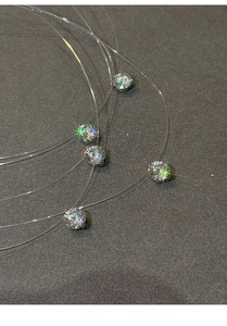 Vista macro di cinque pendenti in zircone brillante su catene in nylon invisibili