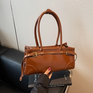 Brown glossy leather tote bag with gold buckle and double handles for women