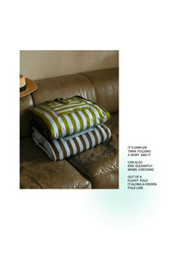 Detail showing foldable travel organizers with stripe patterns on a sofa