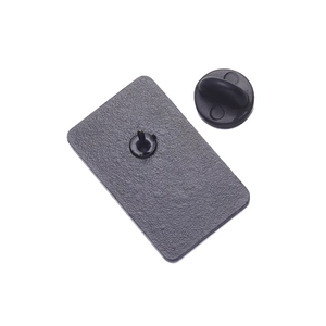 Macro shot of rectangular metal brooch back with textured finish and rubber clutch fastener