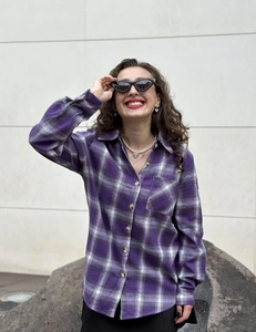 Detailed view of women's purple plaid flannel shirt with front pocket and collar