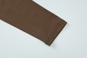 Makroaufnahme der dunkelbraunen Strickmanschette mit doppelten Nahtdetails am Ärmel