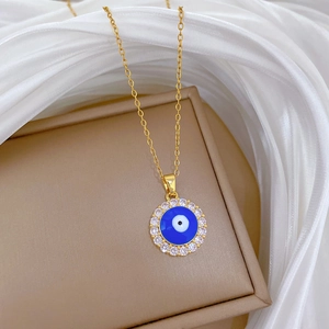 Detailed close-up of gold Evil Eye necklace featuring blue center and white zircon stones