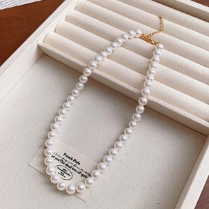 Detail of elegant pearl necklace with gold clasp and adjustable chain on display