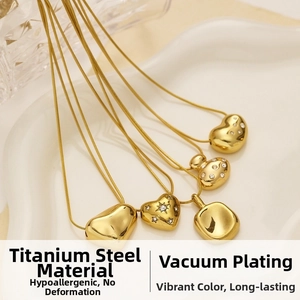 Detail of gold titanium steel necklaces with heart pendants and vacuum plating finish