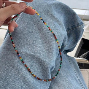 Detail of colorful beaded necklace with S925 sterling silver clasp held against denim