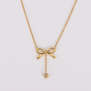 Detail of gold bow necklace with a sparkling round crystal drop on polished link chain