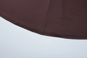 Close-up of dark brown long sleeve dress featuring durable double stitching on hem