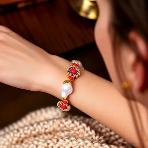 Nahaufnahme des Vintage-Blumenarmbands mit roten Perlen und weißen Perlen am Handgelenk