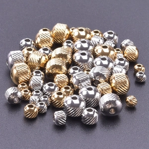Detailed macro view of textured gold and silver 18k plated stainless steel beads with holes