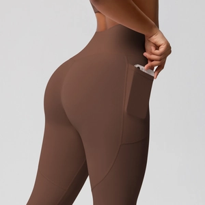 Detail of high-waisted yoga pants with functional side pocket holding a smartphone