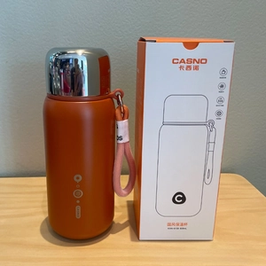 Detail of 600ml orange 316 stainless steel vacuum flask with silver metal lid and strap