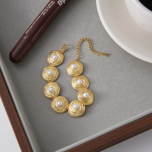 Detailed macro view of 18K gold-plated stainless steel bracelet with concentric pearls