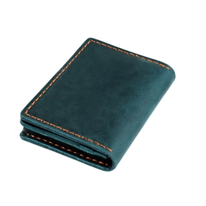 Detail of vintage crazy horse leather wallet with vibrant orange contrast stitching