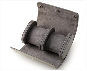 Detail view of grey suede triple watch roll with three independent cylindrical pillows