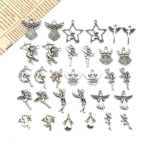 Detail of assorted antique silver angel charms featuring celestial moon and star designs