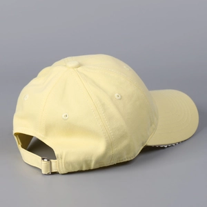 Détail de la casquette jaune clair avec boucle métallique réglable et œillets d'aération