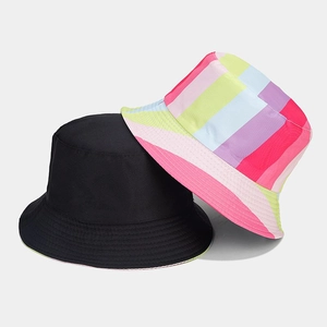 Detail showing reversible bucket hat with black exterior and vibrant rainbow striped pattern