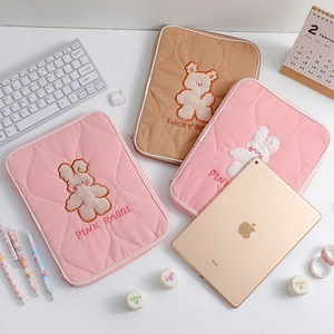 Detailed view of quilted fabric iPad sleeves with cute bear and rabbit embroidery