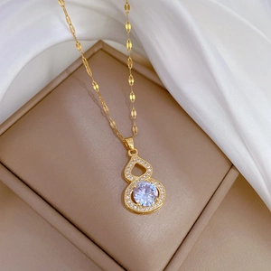 Detail of a luxury gold-plated gourd pendant with micro-inlaid crystals on white silk
