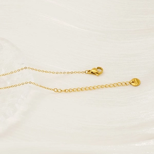 Detail of gold zircon necklace showing lobster clasp and S.STEEL engraved round tag