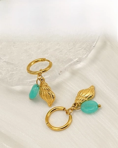 Detail of 18K gold plated shell earrings with turquoise bead on silk background