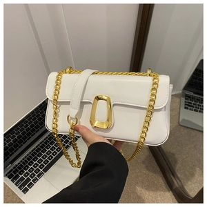 Detailed shot of a white baguette bag with a gold chain strap and stylish clasp closure