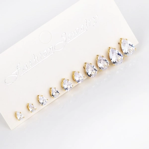 Macro view of multi-size teardrop zircon earrings in gold setting on white card