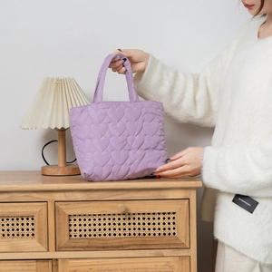 Close-up of purple quilted heart pattern on soft nylon lunch bag with puff texture