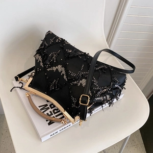 Detail of elegant black evening bag with fine sequins, beads and gold metal frame