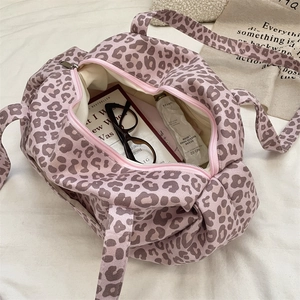 Inside view of a pink leopard print canvas tote bag showing books and ample storage space