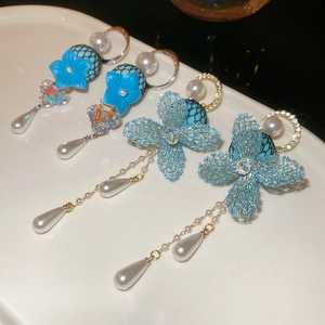 Detail of blue mesh flower earrings with pearl pendants and sparkling rhinestones