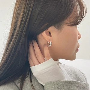 Close-up of minimalist silver geometric U-shaped hoop earrings worn by a model
