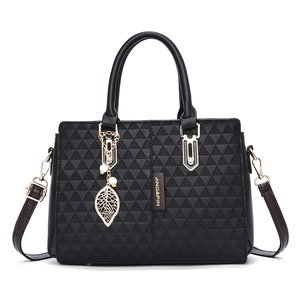 Fashionable black faux leather tote bag with geometric embossed pattern and leaf charm