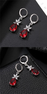 Detail of water drop red gemstone earrings with floral zircon cluster in silver finish