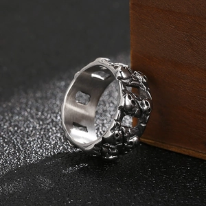 Macro shot of punk style hollow skull ring band showing detailed stainless steel carving