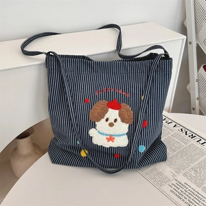 Detailed view of cartoon puppy embroidery on striped navy canvas tote bag with PUPPY LAND text